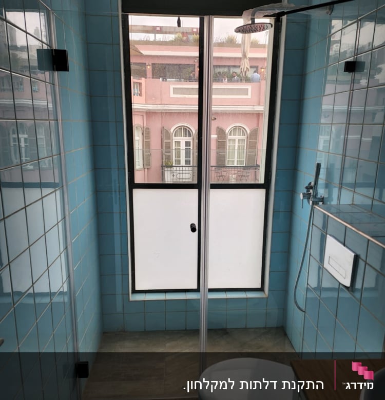 מקלחת עם אריחים כחולים וראש מקלחת עגול